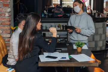 Successful young business people sharing ideas and smiling while working together on a project in a  coffee shop. .