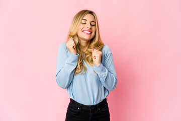 Young caucasian blonde woman makes scale with arms, feels happy and confident.