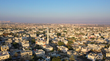 Fototapeta na wymiar Mosque Tower minaret in Jericho city with Birds- aerial view Drone view of Jericho city,sunset, Jordan Valley, Israel/palestine 