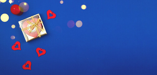 Top view Valentine's Day composition with candles and decorations in form of hearts, blue background, copy space banner