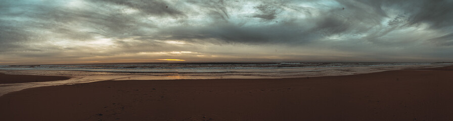 Fototapeta na wymiar Atardecer en la playa de invierno nubes arena reflejos sur de españa
