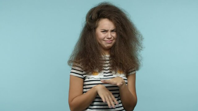 Silly young girl grimacing and looking with aversion, cringe from something disgusting, saying ew and rejecting offer, standing over blue background