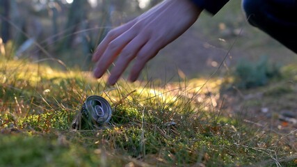 Picking Up Trash Cans and Bottles in Forest with Backlight Sunrise Light