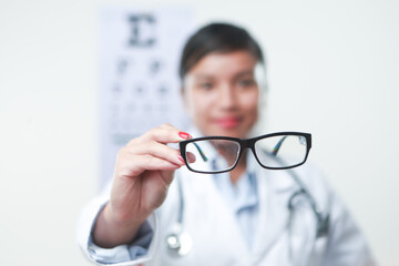 A female doctor with stethoscope and a vision chart