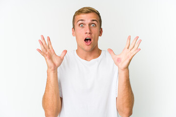 Fototapeta premium Young caucasian handsome man celebrating a victory or success, he is surprised and shocked.