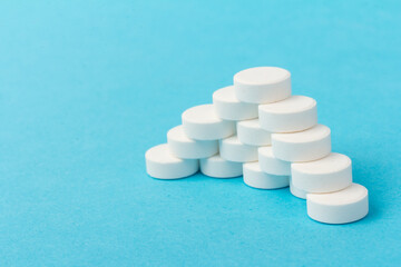 Heap of pills on blue background. Medicine, pharmacy and health concept.