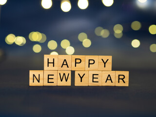 HAPPY NEW YEAR - ciemne tło, napis z drewnianych klocków 