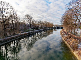 Morgenlicht mit Bewölung und Sonnenlicht am Isarkanal, englischer Garten, München