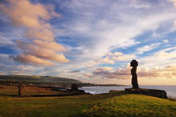 Moai statues at the Ahu Tahai Ceremonial complex on Easter Island, against a colorful sunset sky.