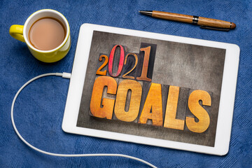 2021 goals - New Year resolutions concept - word abstract in vintage letterpress wood type blocks on a digital tablet with coffee