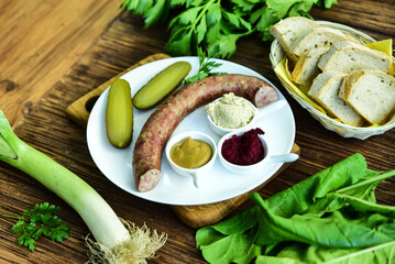 Sausage served with pickled cucumber, mustard, horseradish and bread.