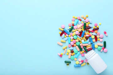 Colorful pills and bottle on blue background