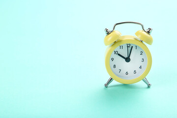 Yellow alarm clock on blue background