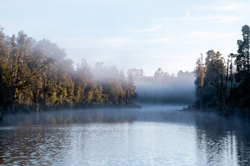 Morning fog rising over Arnold River and native forest at Moana near Lake Brunner, South Island, New Zealand