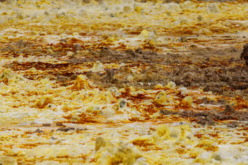 yellow and red stones in a volcanic crater that heat and boil from the heat