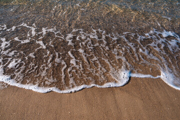 Seascape. Waves running on the sandy shore. Shore of the sea or ocean on a nice day. Vacation and relaxation by the sea.