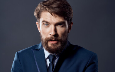 A bearded man in a suit close-up studio dark background businessman