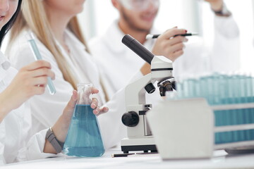 group of young scientists conduct research in the laboratory .