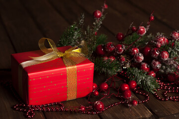 Gift in a red package. Christmas and New Year. Bow and packing tape. Valentine's Day. On a wooden background.