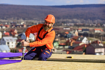 Picky inspector. new roof under construction residential building. builder use drill. professional...