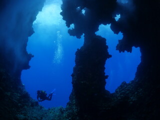 Fototapeta na wymiar cave diving underwater scuba divers exploring caves ocean scenery sun beams and rays background