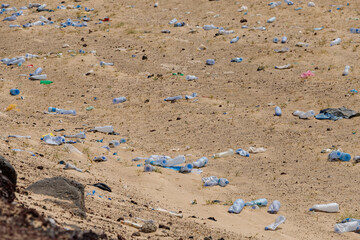 in the desert tossed in the sand a lot of plastic bottles and other waste