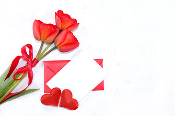 Postcard for Valentine's Day or Women's Day, concept, hearts, flowers and gift envelope on a gray...