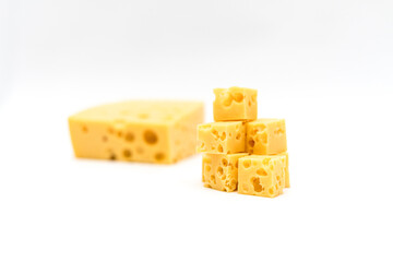 Dumpling of hard cheese with holes and cubes on a light background