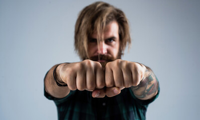 mature brutal hipster with lush moustache in shirt showing fists, punch
