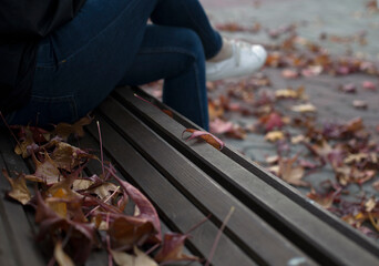 A man sits on a bench in an autumn park.
