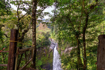 A young man riding on a zip line rope in an extreme adventure jungle in Xico, Veracruz, Mexico