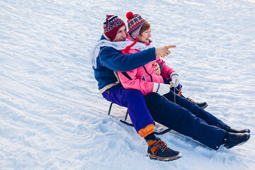 Sleigh. Senior couple sledding down. Family having fun in winter park. Winter activities