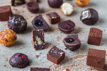 Chocolate truffles and candies on light stone background. Homemade dark chocolate truffles and candies with cocoa powder. Close up.
