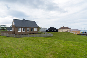 Obraz premium Traditional Icelandic houses in a coastal village on a cloudy summer evening. Stykkishólmur, Iceland.