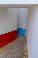 small corridor leading through typical white wall and colorful Portuguese houses