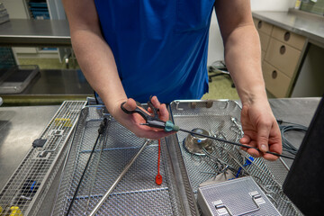 in sterilization department of a hospital, surgical instruments are sorted into trays after cleaning