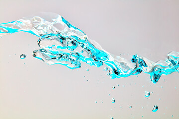 Nahaufnahme einer blauen Welle und Luftblasen vor hellem Hintergrund.