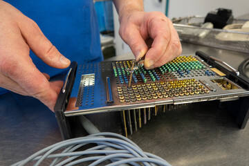 many different types of titanium surgical screws are sorted into a tray according to size and type