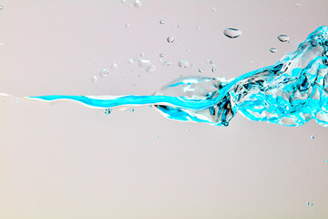 Nahaufnahme einer blauen Welle und Luftblasen vor hellem Hintergrund.