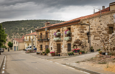 Fototapeta na wymiar a street with typical houses in Cabrejas del Pinar town, province of Soria, Castile and Leon, Spain