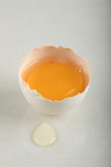 Raw broken egg on white background