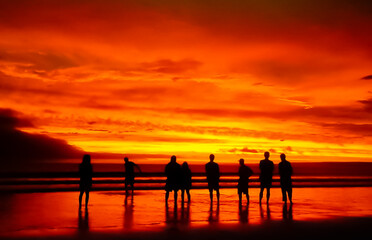 Fototapeta na wymiar Beautiful sunset ocean sea beach orange sky people silhouette