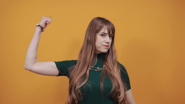 Feels proud have strength, shows great power, raises arms to show muscles confident in victory, looks strong and independent, flexing arm, facial expressions, feelings, attitude, life perception