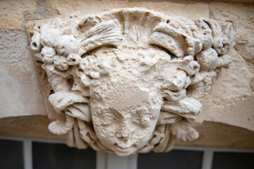visage en pierre sculpté usé par le temps