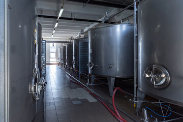 Naklejka na ściany i meble Stainless steel barrels and tanks and other containers for liquids in the food industry. Industrial production of alcoholic or soft drinks.