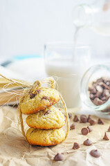 Chocolate chip cookies served with milk on rustic background