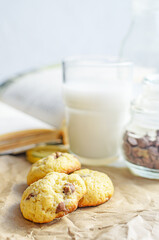 Chocolate chip cookies served with milk on rustic background