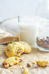 Chocolate chip cookies served with milk on rustic background