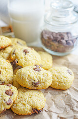 Chocolate chip cookies served with milk on rustic background