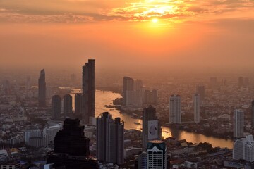 Aerial view of Bangkok cityscape at sunset along Chao Praya River, Bangkok, Thailand.